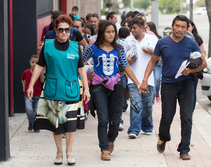 Catholic Charities volunteer Blanca Muñoz (left) leads immigrants who were recently released from a U.S. Border Patrol detention facility to the Humanitarian Respite Center in McAllen, Texas, where they can shower, eat and rest while waiting for buses that will take them to friends or family elsewhere in the U.S. Photo by Mike DuBose, UMNS.