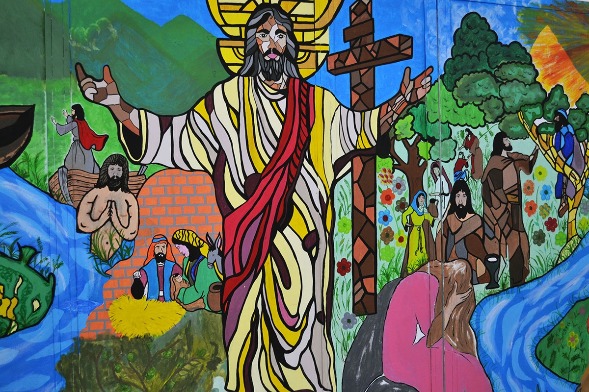 Al rededor de esta pintura mural que muestra la imagen de Jesús y diferentes episodios de las escrituras, se dieron cita líderes clérigos/as y laicos/as en Ciudad España, para coordinar acciones en favor de la población migrante hondureña.