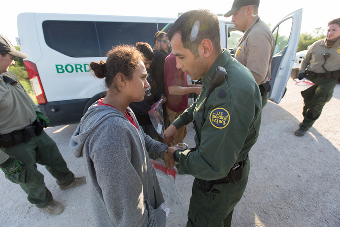 Border patrol agents come to the aid of a fellow agent who became overheated while searching a sugarcane field for people who entered the U.S. illegally. Photo by Mike DuBose, UMNS.