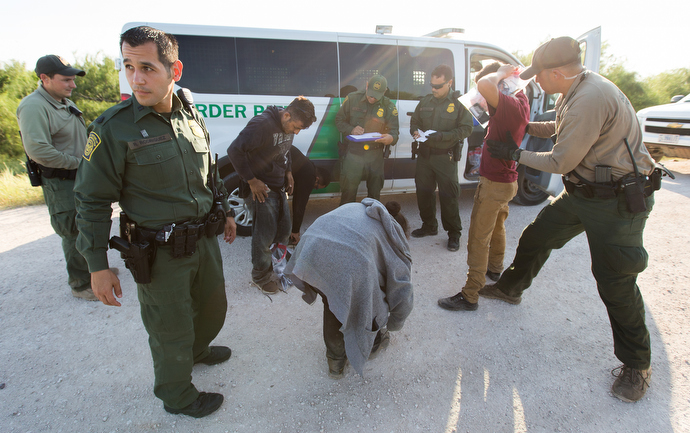 Border patrol agents search people caught entering the U.S. illegally before transporting them to a detention center in McAllen. Photo by Mike DuBose, UMNS.