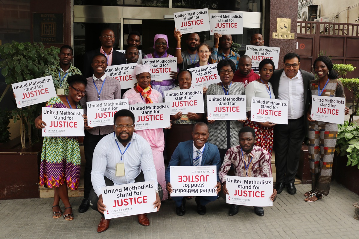 United Methodists hold up signs about justice after discussions in Luanda, Angola, about proposed revisions to the Social Principles of The United Methodist Church. Photo by Orlando da Cruz, UMNS.