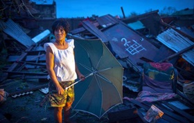 An unidentified woman stands by a collapsed building struck by Typhoon Mangkhut in the Philippiines.  Photo courtesy of Cagayan provincial information office.