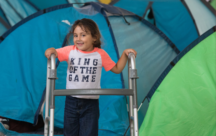 A child plays with a relative's walker amid rows of camping tents that provide some privacy for families at the Movimiento Juventud 2000 shelter. Photo by Mike DuBose, UMNS.