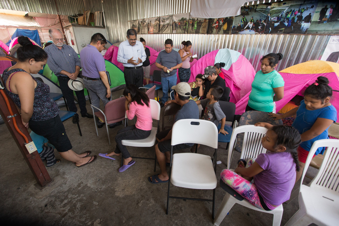 Bishop Felipe Ruiz Aguilar of the Methodist Church of Mexico (fourth from left) leads a prayer with families and visiting United Methodists at the Movimiento Juventud 2000 shelter. Photo by Mike DuBose, UMNS.