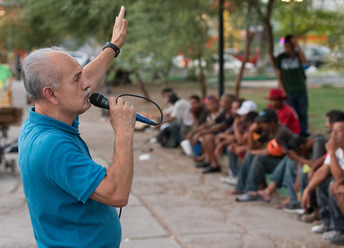 Victor Rodriguez shares his own story of homelessness and addiction with migrants and others living on the street during a dinner and worship service at Mariachi Plaza. Photo by Mike DuBose, UMNS.