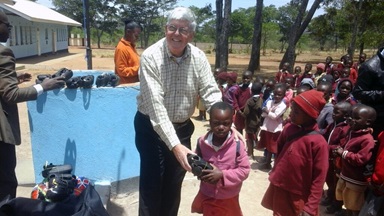 Charlie Moore, a member of Community United Methodist Church in Crofton, Maryland, and team leader of the Zimbabwe Volunteers in Mission, hands shoes to a student at Hanwa Mission School in Zimbabwe. For over 20 years, the U.S. church has been working with United Methodists in the Zimbabwe West Conference to improve lives in the rural Murewa District. Photo by Chenayi Kumuterera, UMNS.