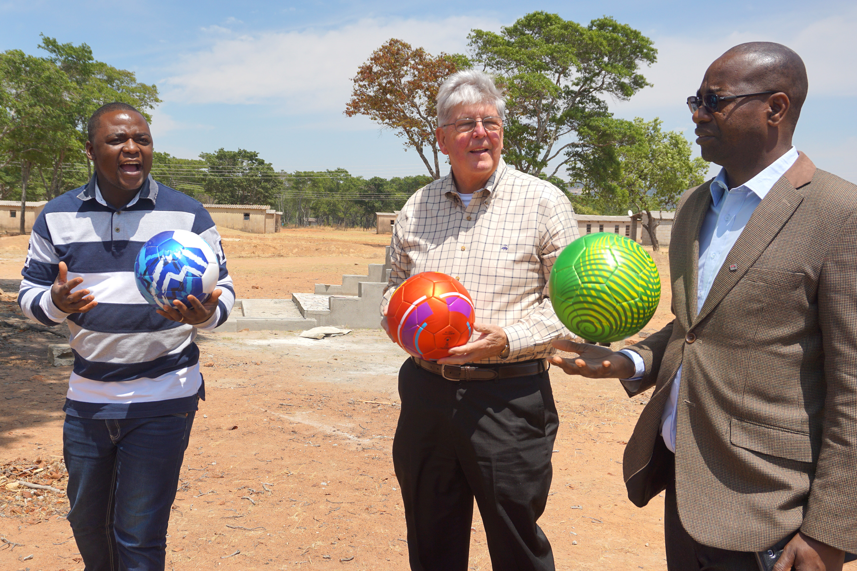 The Rev. Future Sibanda, left, Charlie Moore and the Rev. Henry Luckson Chareka hold soccer balls donated to students at Hanwa Mission School in the Murewa District of Zimbawe as part of a partnership between Community United Methodist Church in Crofton, Maryland, and United Methodists in the Zimbabwe West Conference. Photo by Chenayi Kumuterera, UMNS.