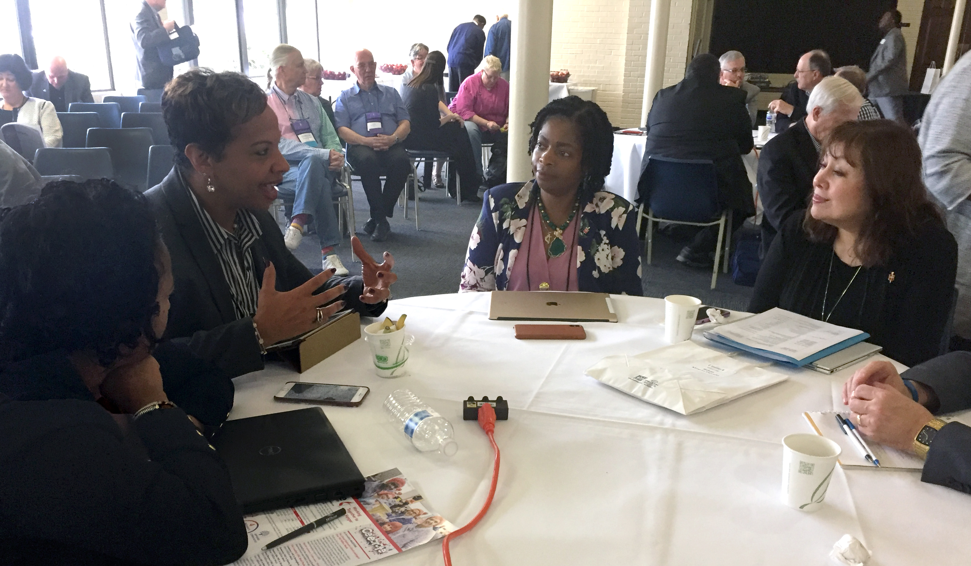 Bishops gather in small groups to discuss what scriptural imagination means in this uncertain season in the church. From left are Bishops Sharma Lewis, Tracy Smith Malone (speaking), Cynthia Moore-Koikoi and Minerva Carcaño. Photo by Heather Hahn, UMNS.