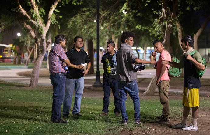 Bishop Felipe Ruiz Aguilar of the Methodist Church of Mexico (left) visits with migrants who have recently arrived from Honduras at Mariachi Plaza in Mexicali, Mexico, in August 2018. File photo by Mike DuBose, UMNS.