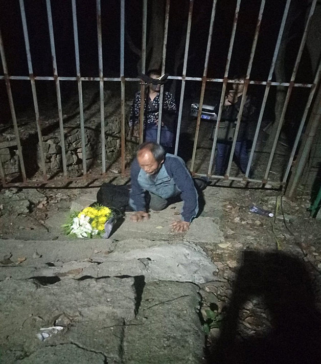 Chinese activist Zhu Chengzi works his way under a fence at the Lingyanshan Cemetery in Nanjing, China, in this undated file photo. He intended to pay tribute to dissident Lin Zhao, who was executed in 1968. He was arrested by Chinese authorities and is still in custody as of October 2018.  Photo courtesy of Lian Xi.