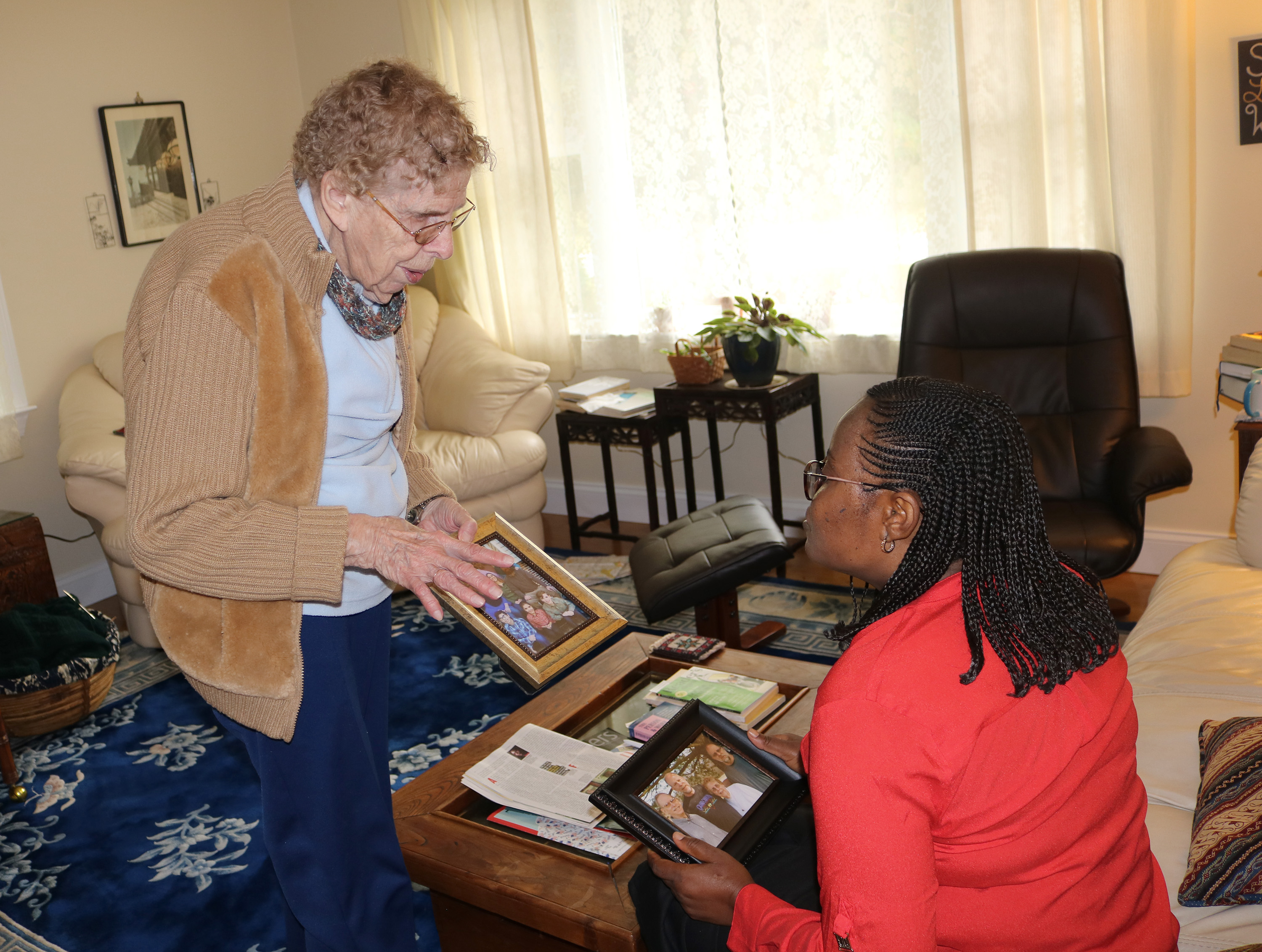 Dusty Knisley (left) of Calvary United Methodist Church in Dillsburg, Pa., shares her family story and photos with the Rev. Daisy Gbloh from Sierra Leone. Knisley hosted a team from the Sierra Leone Conference at her home. Photo by Phileas Jusu, UMNS.