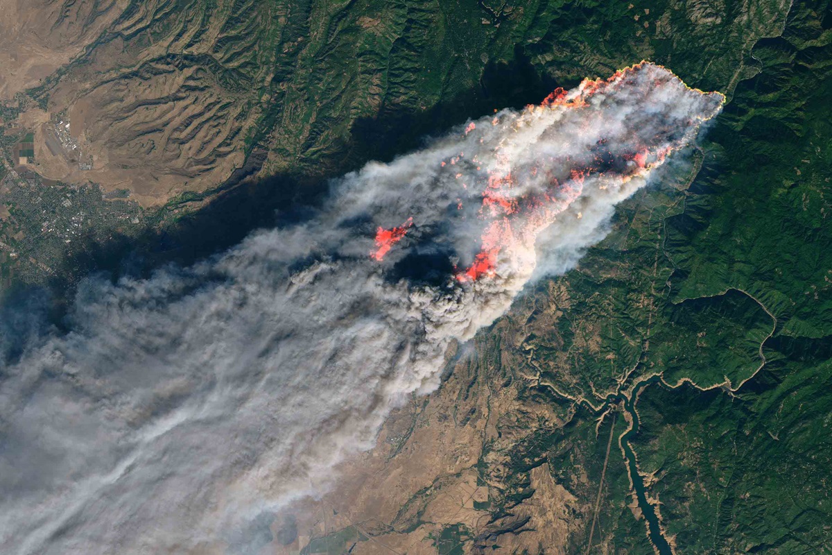 A satellite image shows smoke pouring from a wildfire that broke out in the early morning hours of Nov. 8, just outside Paradise, Ca. The Camp Fire, named for its proximity to Camp Creek Road in Feather River Canyon, has overtaken and nearly burned out the town of 30,000 residents located in northern California. NASA Earth Observatory image by Joshua Stevens, using Landsat data from the U.S. Geological Survey.