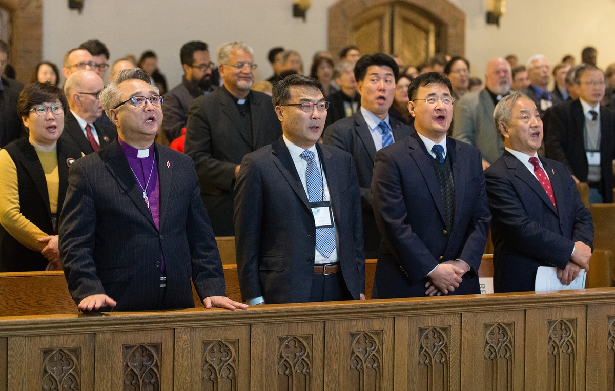 Delegates and guests sing during closing worship at the Roundtable for Peace on the Korean Peninsula at Grace United Methodist Church in Atlanta. Front row, from left are: Bishop John Higon Eun, American Conference of the Korean Methodist Church; the Rev. Chongho James Kim, First United Methodist Church of Flushing, N.Y.; the Rev. Kim Sei Hwan, Korean Church of Atlanta United Methodist Church; and Bishop Hee-Soo Jung, Wisconsin Conference of The United Methodist Church. Photo by Mike DuBose, UMNS.