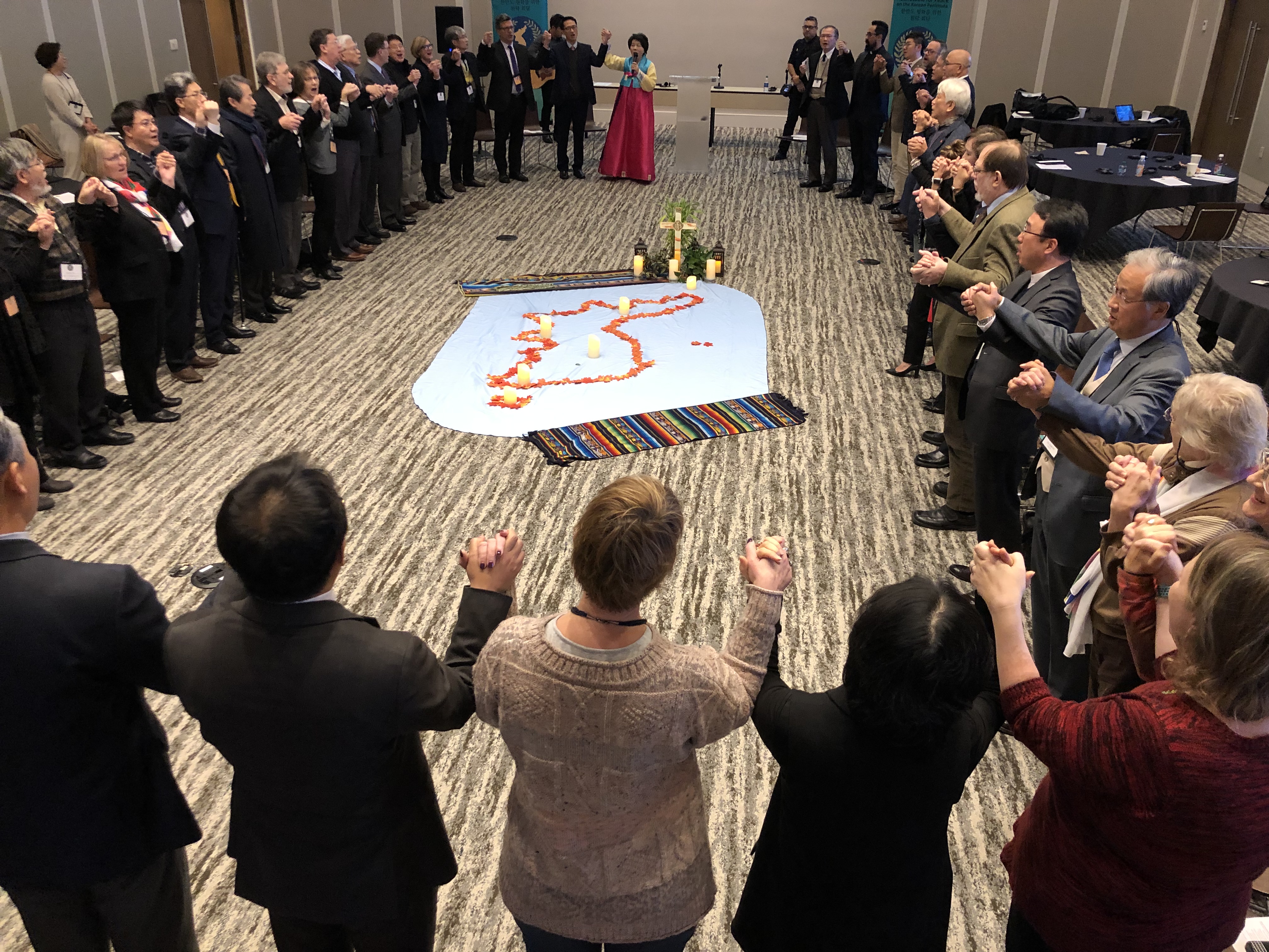 한반도 평화를 위한 원탁 회담에 참석자들이 주일 예배 중 손에 손을 잡고 찬송을 하고 있다. 사진 김응선 목사, UMNS