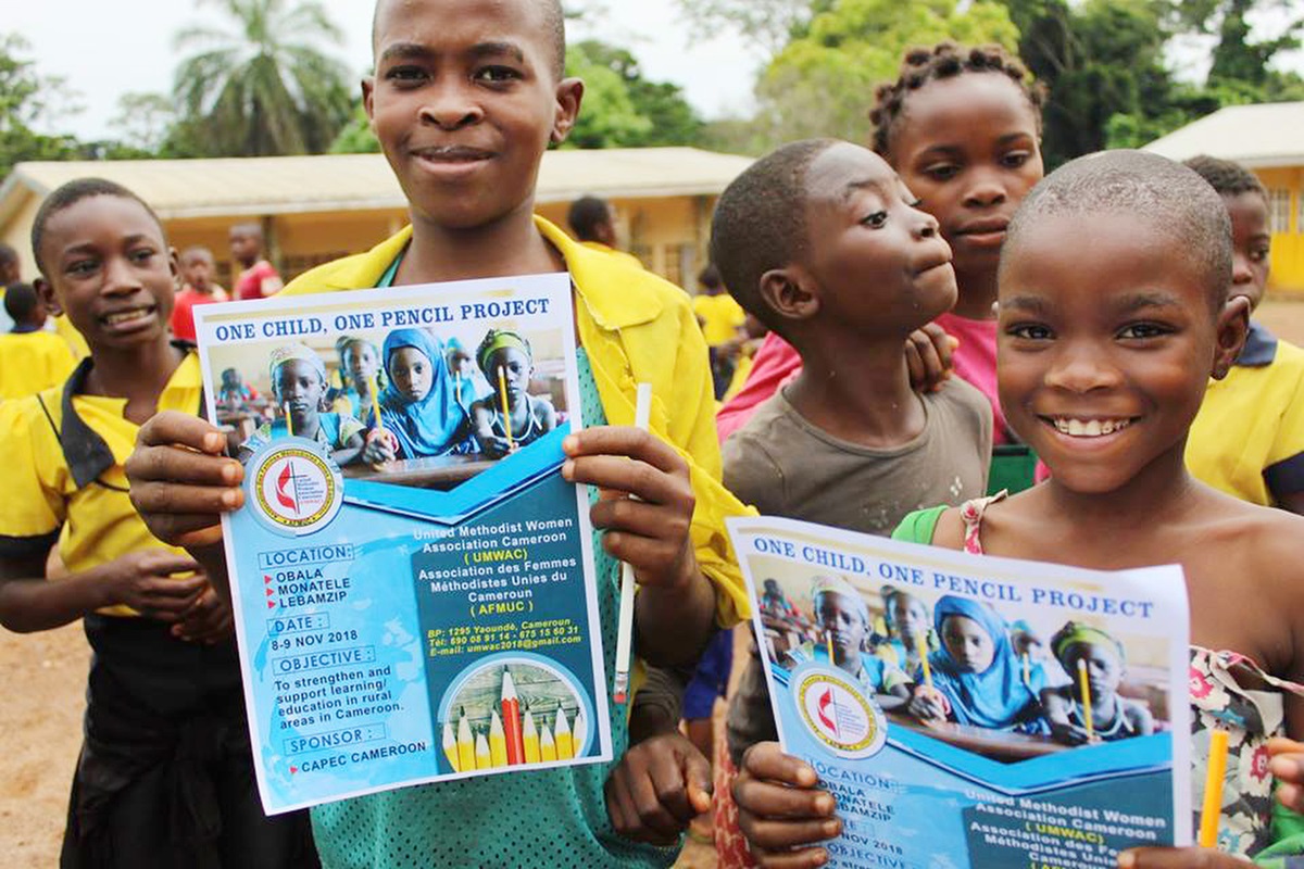 Students hold posters describing the One Child, One Pencil Project, a community outreach and evangelism campaign sponsored by United Methodist Women. Photo by Marius Bonfeu.