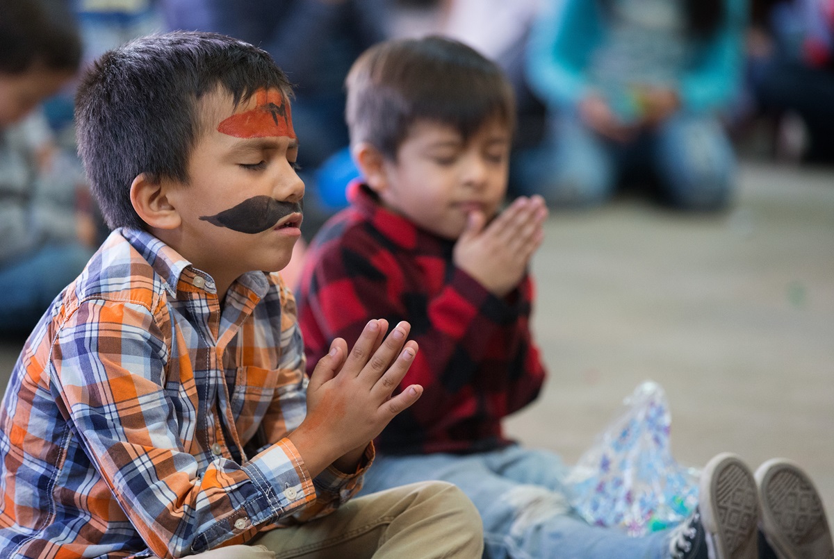 Children pray during a Christmas party at the Door of Hope Salvation Army shelter in Tijuana, Mexico. Migrant children who are staying with their mothers at the shelter joined with kids from the neighborhood and volunteers from the Methodist Church of Mexico in the celebration. Photo by Mike DuBose, UMNS.