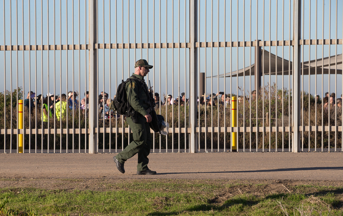 A U.S. Border Patrol agent walks through Friendship Park in San Diego, between the primary and secondary border fences that separate the U.S. from Mexico, during the 25th anniversary of La Posada Without Borders. 