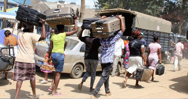 Families carry belongings after their apartments were demolished in Nairobi, Kenya. Photo by Gad Maiga.