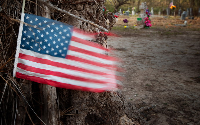 A U.S. flag flutters in the breeze outside the Eli Jackson Cemetery in San Juan, Texas. Descendants of the Jackson family are fighting to save the cemetery from being destroyed by a section of the proposed border wall along the Rio Grande. Photo by Mike DuBose, UMNS.