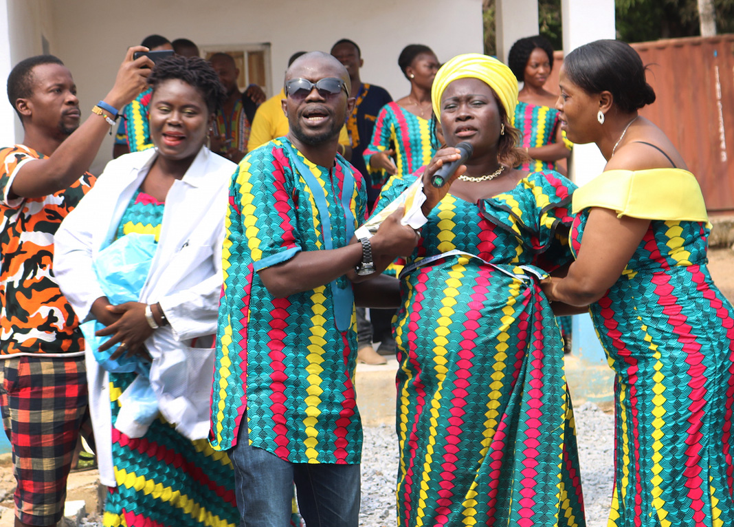 Staff at United Methodist Mercy Hospital in Bo, Sierra Leone, act out a skit at the hospital after the dedication of a new surgery wing. The performance told the story of a pregnant woman who lost her first three children at birth. Thanks to the new surgical center, she was able to give birth to a healthy baby girl via cesarean section. Photo by Phileas Jusu, UMNS.
