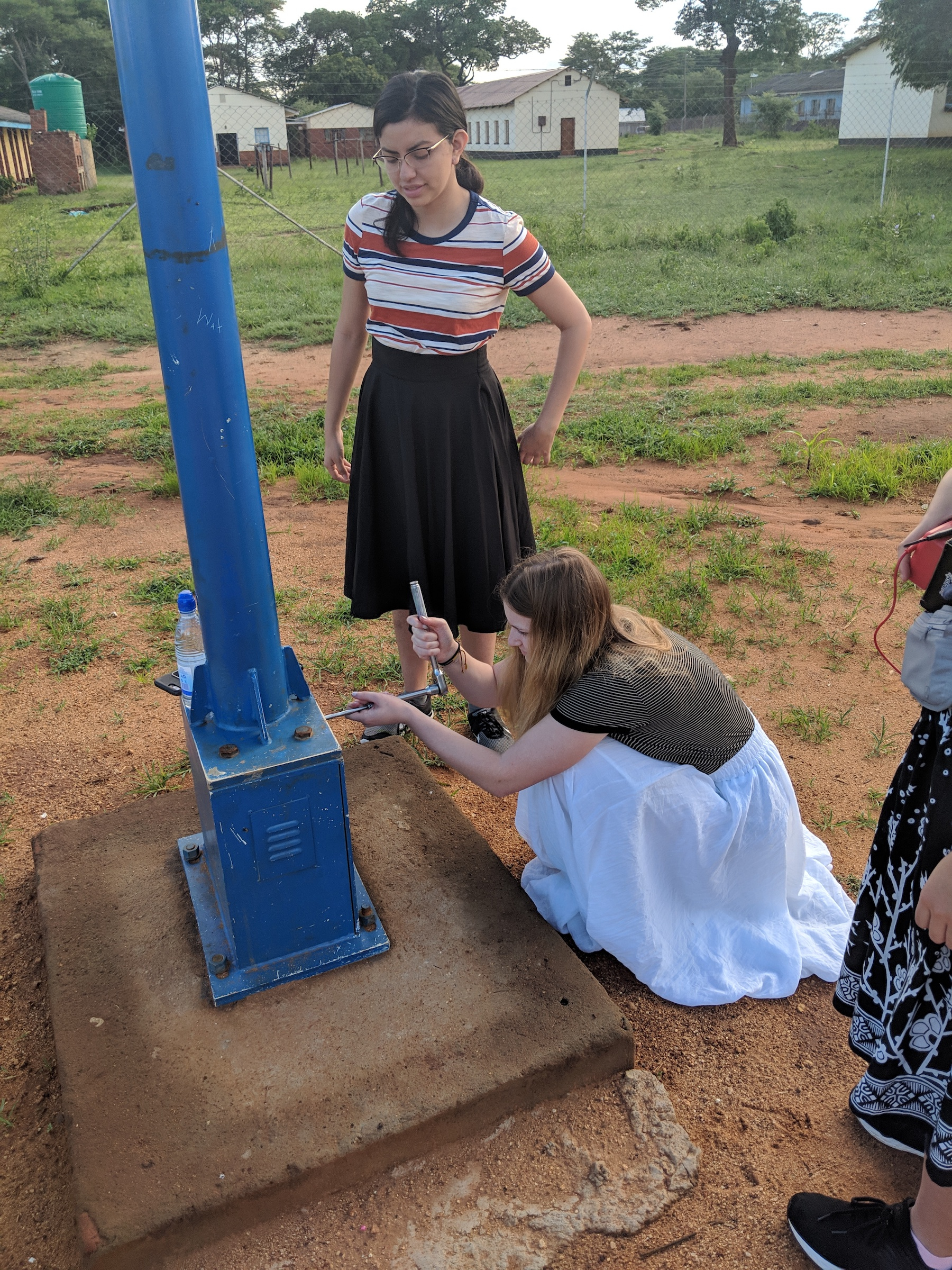 Melina Driscoll and  Ashley Burbano, team members with Engineers Without Borders USA,  inspect lights at Nyadire Mission. Photo courtesy of Chenayi Kumuterera. 