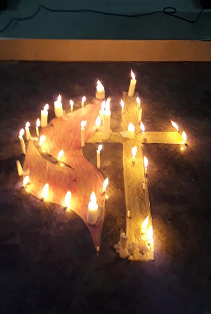 A cross and flame is surrounded by candles during a cluster prayer service at Dumoy United Methodist Church in Davao City, Philippines. Photo courtesy of Dania Soriano.