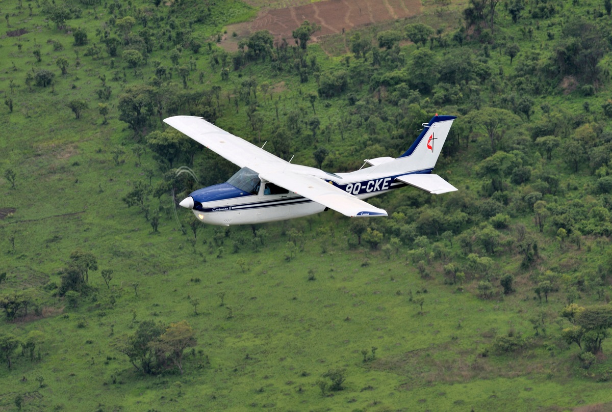 A Cessna T210 piloted by Rukang Chikomb flies through the skies over Congo in 2008. Part of the Wings of the Morning aviation ministry of The United Methodist Church, the program provides life-saving access to isolated rural communities. The photo was taken from another plane, a Cessna P210 piloted by Gaston Ntambo, that is part of the same program. File photo by Paul Jeffrey. 