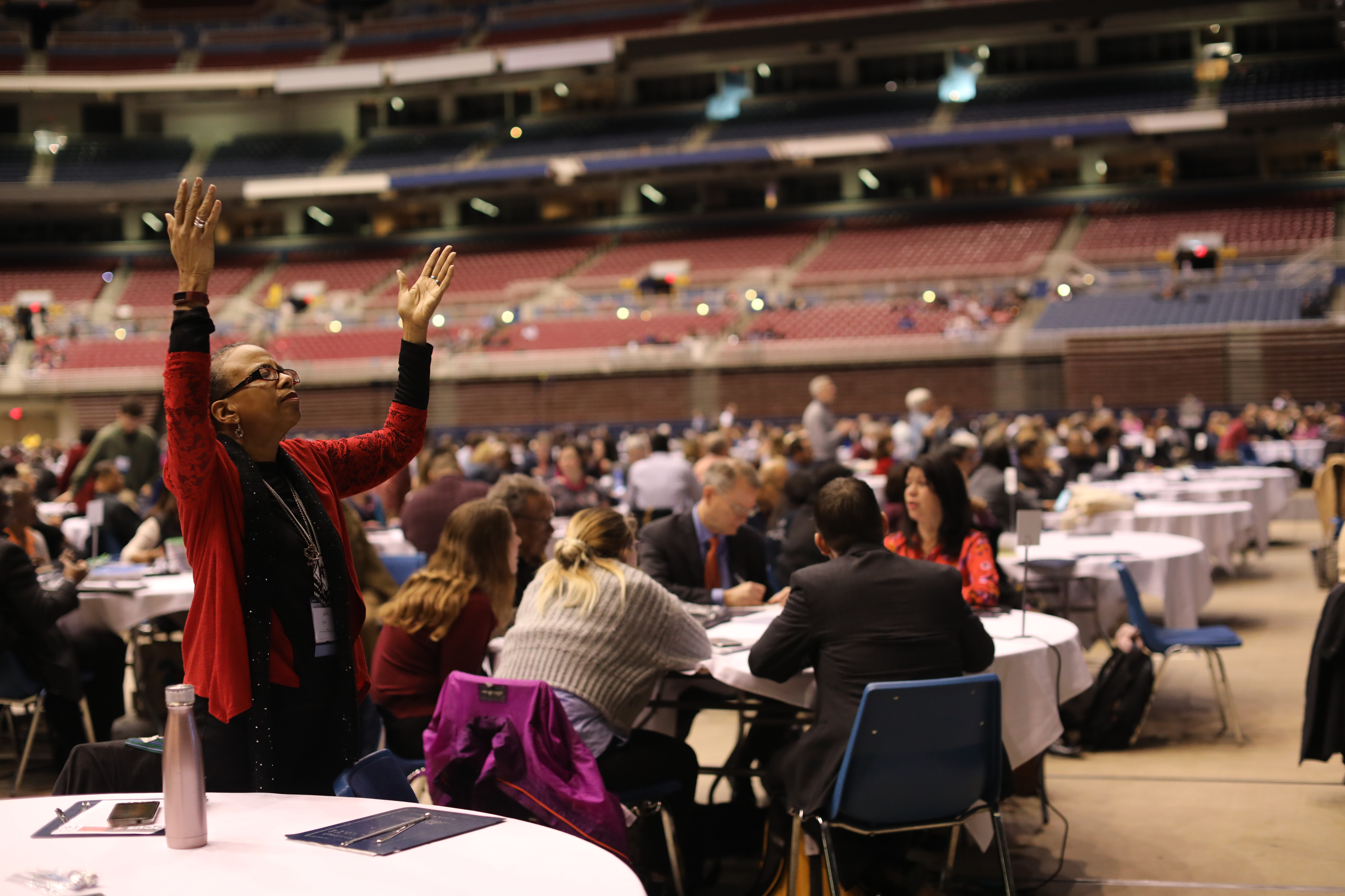 Cheryl Jefferson Bell, delegate (standing) from the Great Plains Conference, raises her hands in prayer during the Feb. 23 morning of prayer at the 2019 Special Session of the United Methodist General Conference in St. Louis.  Photo by Kathleen Barry, UMNS.