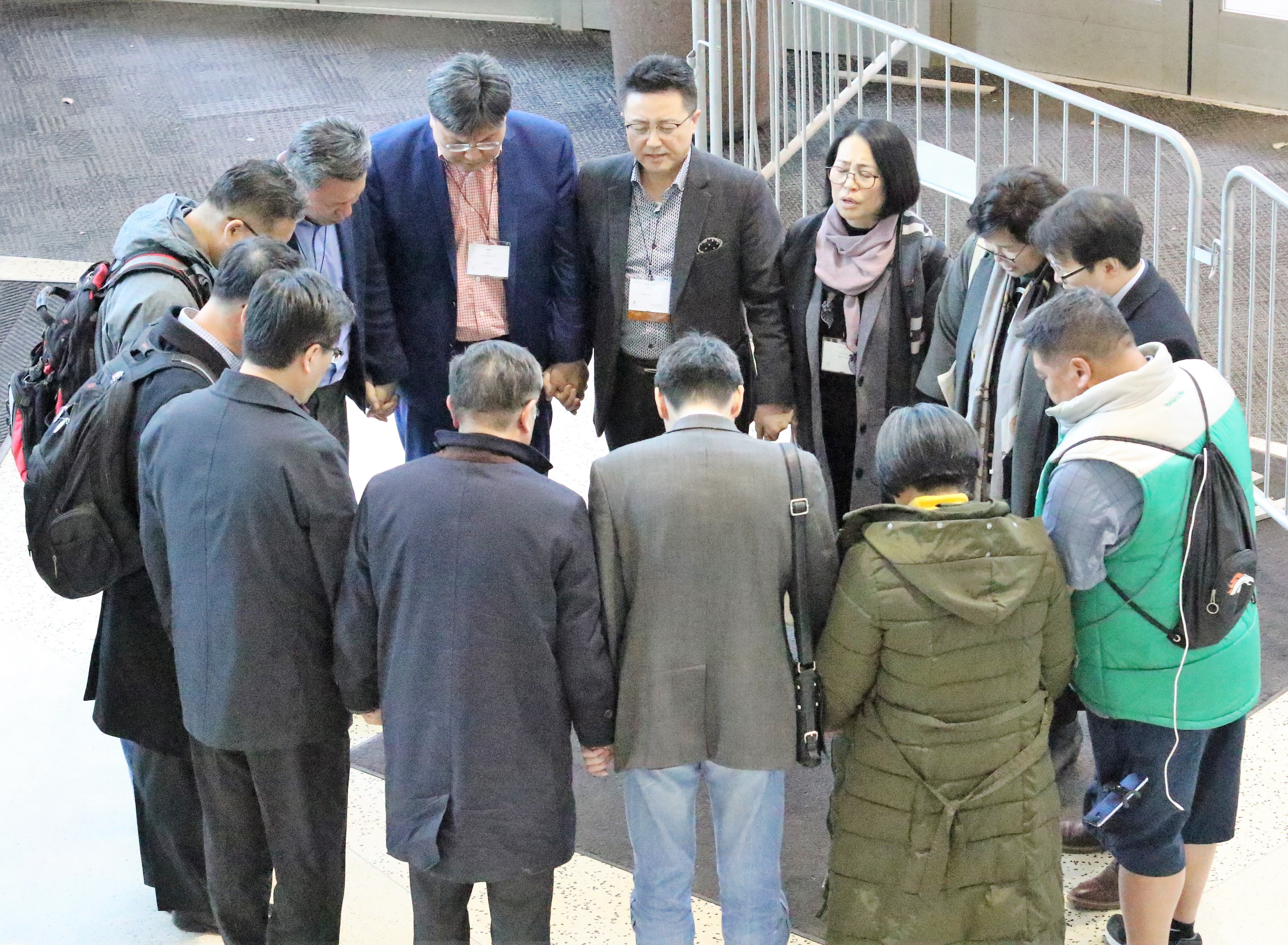 총회 기간에 한인연합감리교인들이 총회장 입구에서 기도하고 있다. 사진 김응선 목사, UMNS