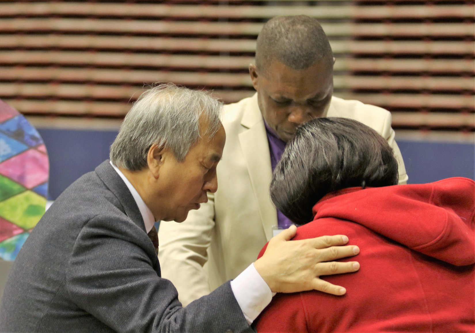 Bishop Hee-Soo Jung, left, prays with delegates during a Day of Prayer on the first day of General Conference 2019 in St. Louis. Photo by the Rev. Thomas Kim, UMNS.