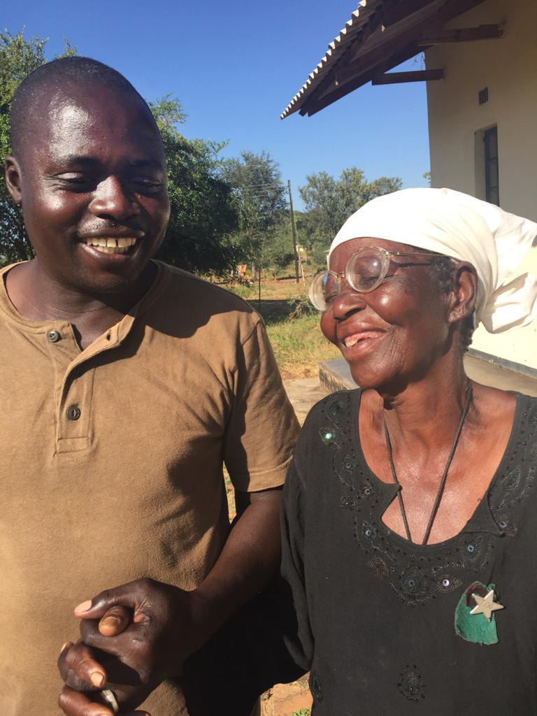 Artwell Chidhakwa, a driver at United Methodist Nyadire Mission Hospital, holds hands with Maduni Jangamu at an eyeglasses clinic in Dindi, Zimbabwe. Photo by Chenayi Kumuterera, UMNS. 