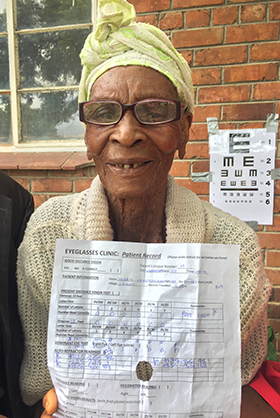 Gladis Chikoto, who is 110 years old, shows off her new glasses and test results after attending an eyeglasses clinic in rural Zimbabwe. Photo courtesy of Don Ziegler.