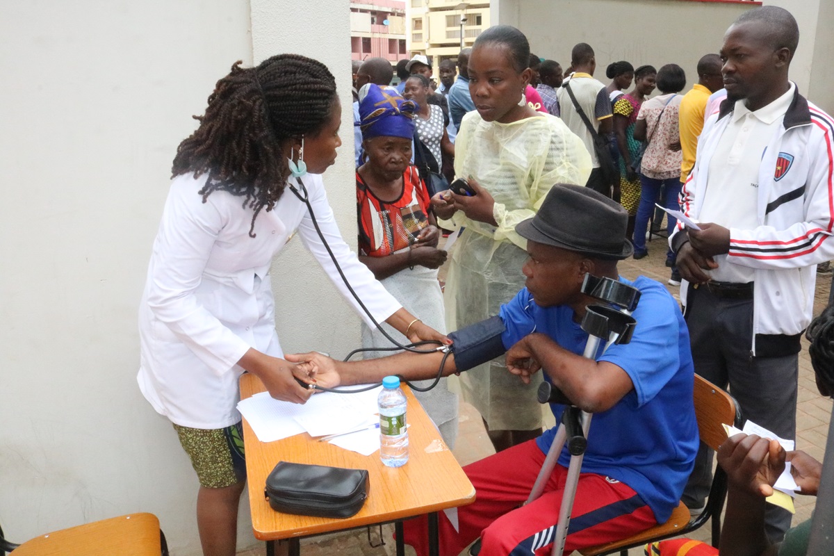 Dra Joana Fernandes, medindo tensao arterial a um paciente na feira de saude organizada pela Associação de Saúde da Juventude da Igreja Metodistas Unidos (ASJIMU)a 04 de  Fevereiro de 2019, no Municipio de Malange.