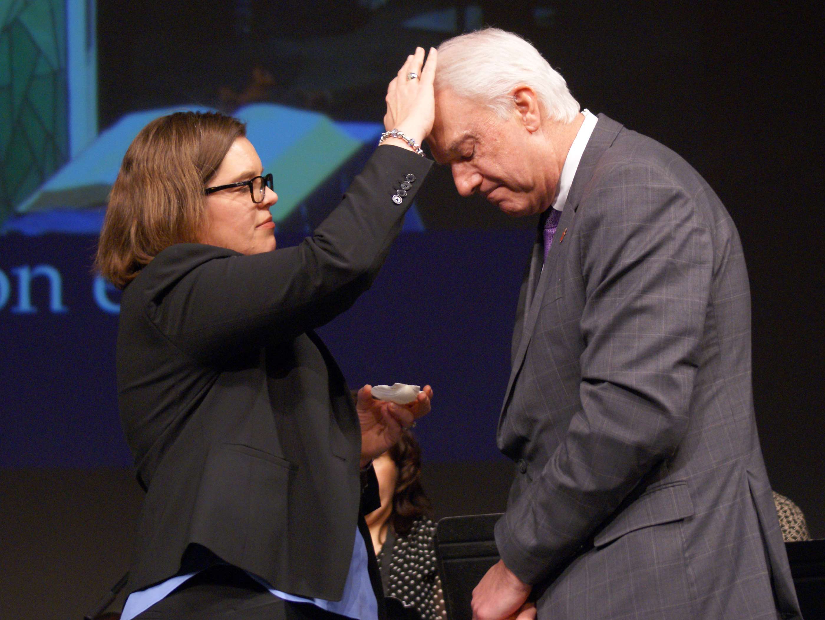 The Rev. Heather Sinclair anoints Bishop Thomas J. Bickerton at the beginning of a time of healing prayer and anointing at the close of a special session of the New York Annual Conference at Purchase College, State University of New York. Photo by Stephanie Parsons.