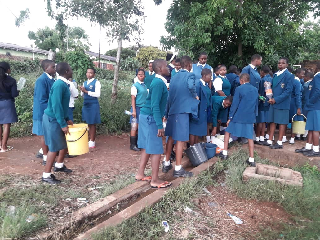 Lydia Chimonyo Estudantes da High School de meninas carregam baldes para coletar água em um poço em Chimanimani, Zimbábue. Não há água corrente na escola desde que o Ciclone Idai danificou a estação de tratamento da água da escola. Foto do Rev. Duncan Charwadza.