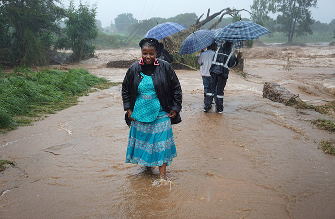 Kudzai Chingwe vadeia através das águas da enchente no Centro Missionário de Mutambara, no distrito de Chimanimani, no leste do Zimbábue. Foto da Rev. Juliet Mwarumba.