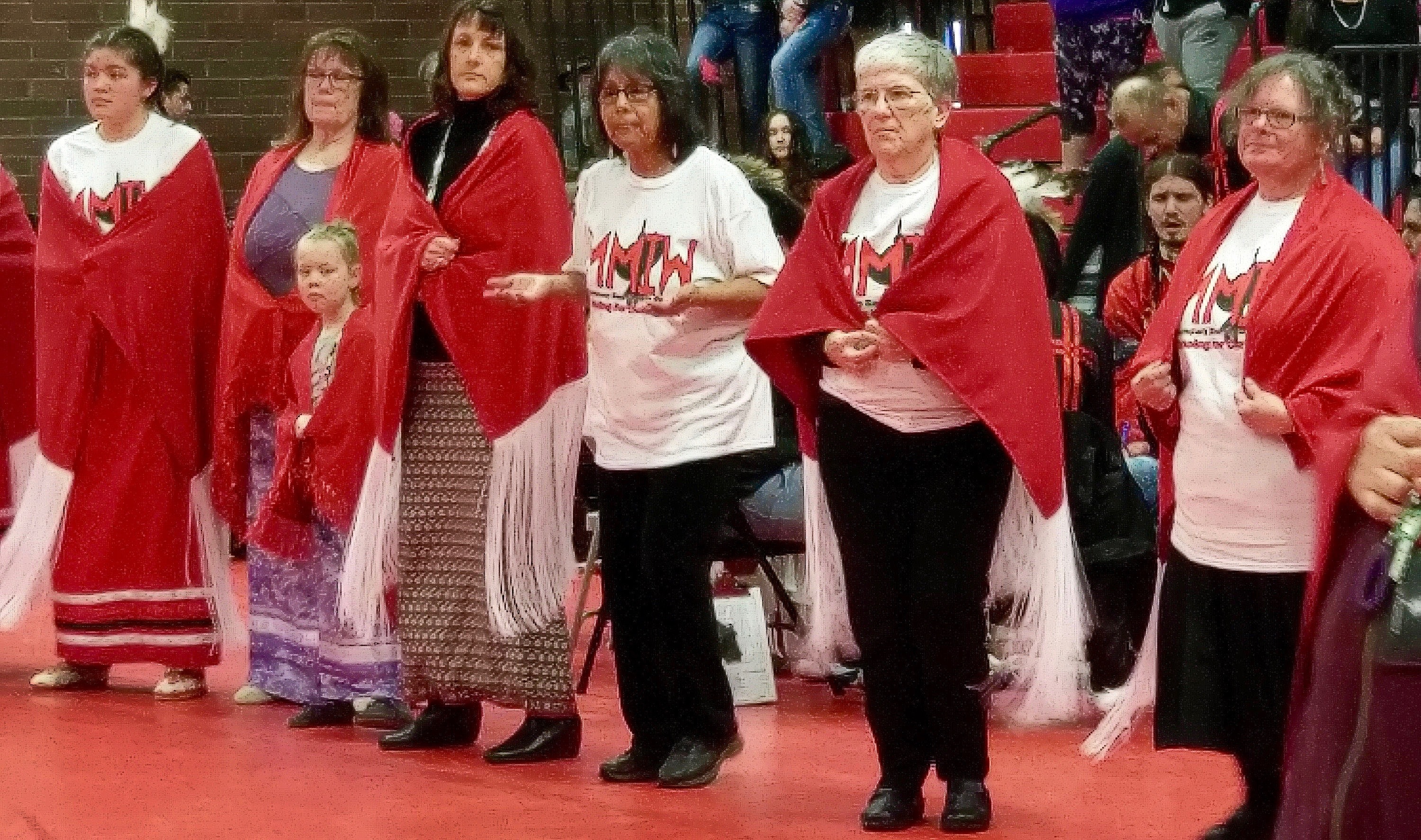 Women from Morningside United Methodist Church in Salem, Oregon, wear red shawls they helped to create during a dance to honor murdered and missing indigenous women at Chemawa Indian Boarding School. Photo by A. Wolf.