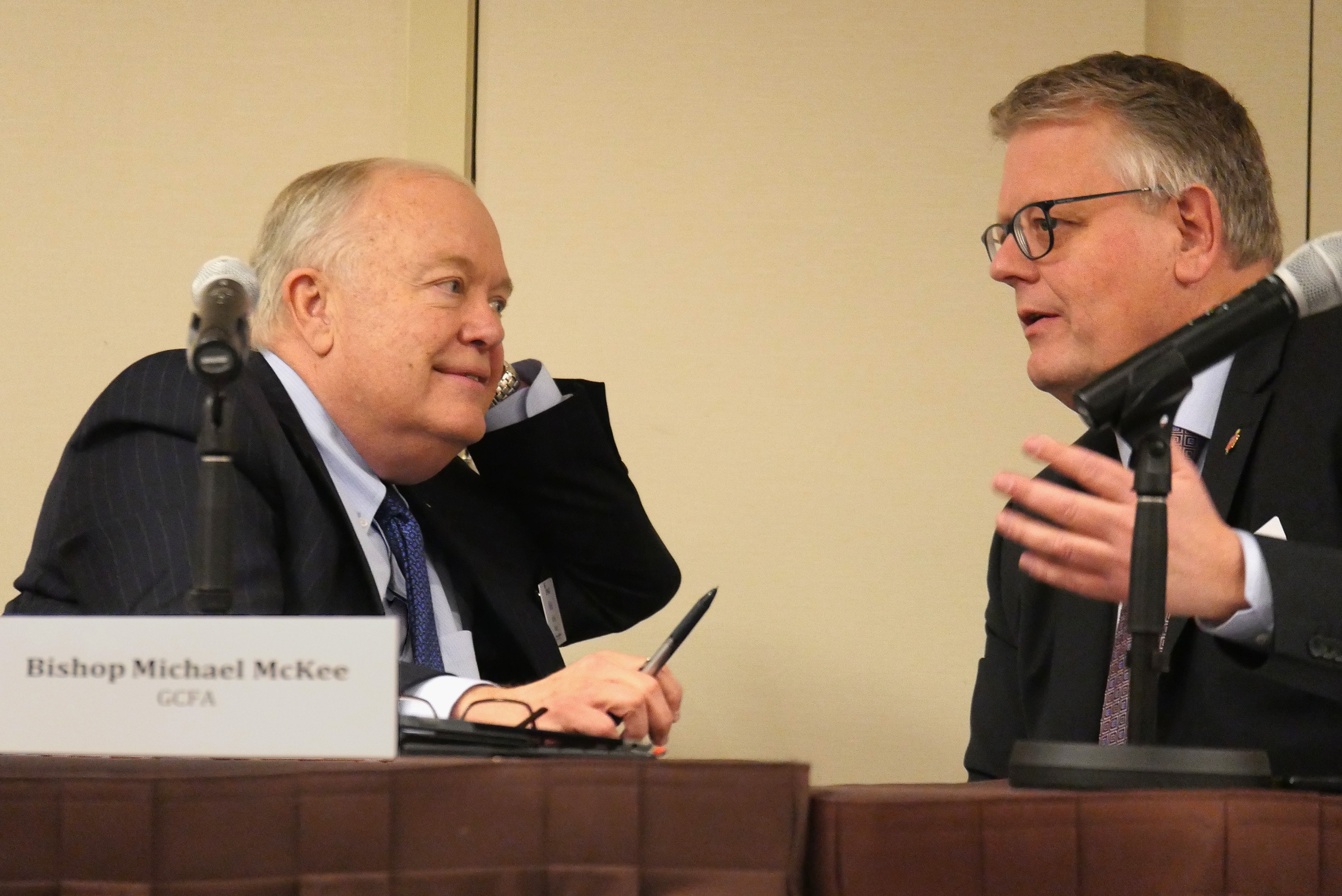 Bishops Mike McKee and Christian Alsted discuss the process for voting on budget proposals during a joint meeting of the General Council on Finance and Administration board and Connectional Table in Nashville, Tenn. McKee is president of the finance agency board and Alsted is chair of the Connectional Table. Photo by Heather Hahn, UMNS.