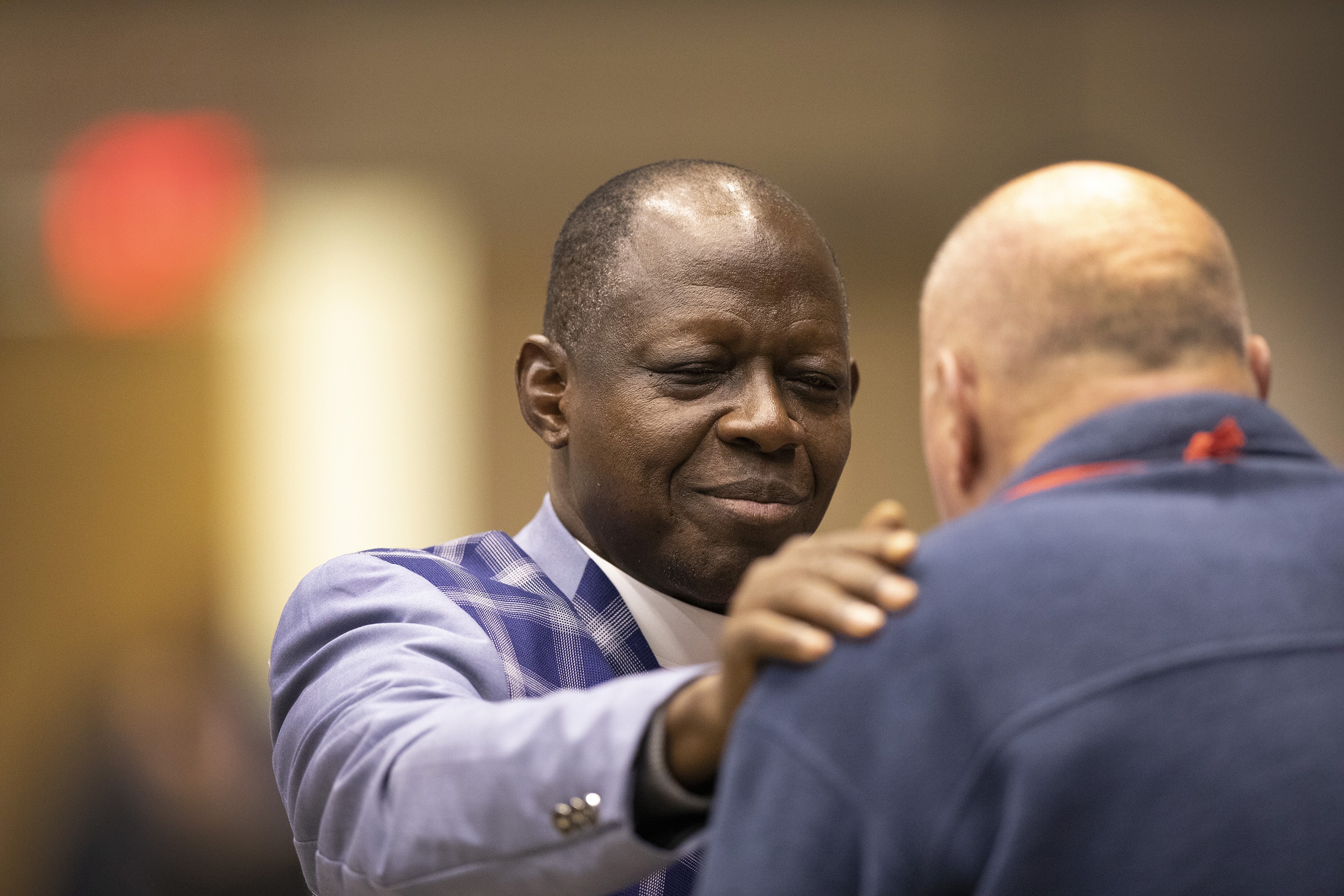 Bishop John K. Yambasu prays with the Rev. Byron Alexander, a conference page, during the 2019 General Conference in St. Louis. Photo by Kathleen Barry, UMNS.