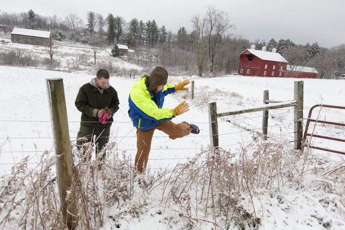 Andy (left) and Jim climb a fence while doing chores at Brookside Farm, part of the Jacob's Ladder recovery home. The program uses the rhythms of farm life to help model a healthy lifestyle. Photo by Mike DuBose, UMNS.