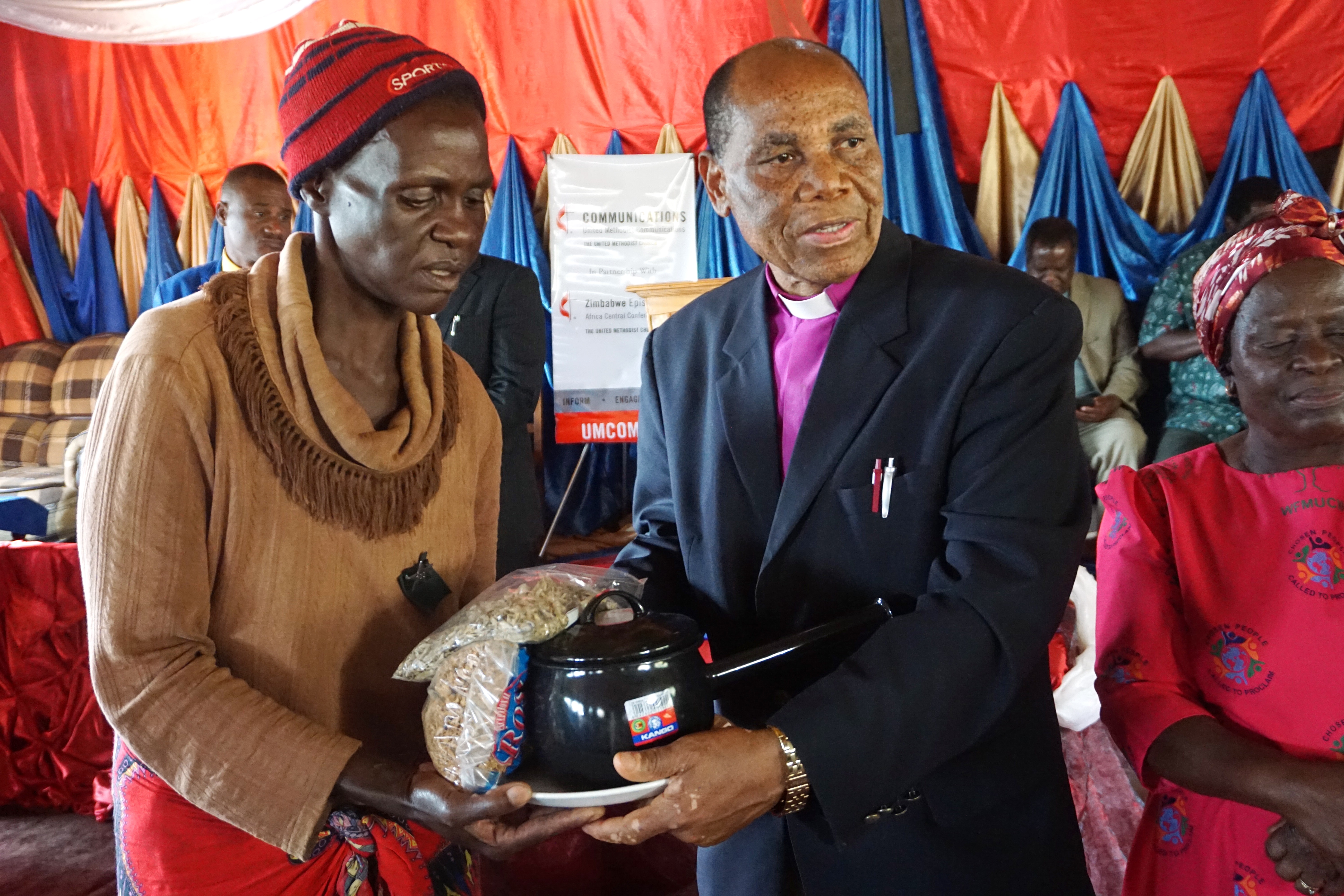 Cyclone survivor Josephine Mutambambishi receives supplies from Bishop Eben K. Nhiwatiwa in Ngangu, Zimbabwe. The bishop and other church leaders visited the hard-hit area in the Chimanimani District in late April. Photo by Kudzai Chingwe, UMNS.
