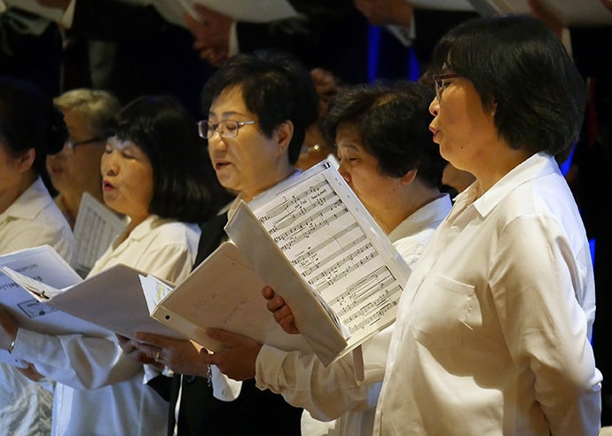 Members of the Hallelujah Choir of First Korean United Methodist Church in Wheeling, Ill., rehearse ahead of opening worship at the Council of Bishops meeting in Chicago. Photo by Heather Hahn, UMNS.