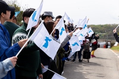 <비무장지대 평화인간띠운동>에 참여한 한국인들이 한반도기를 들고 있다. 사진제공: 박종천 목사(세계감리교협회의 회장) 