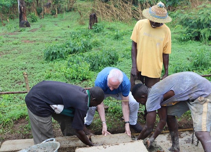 The Rev.  Gary Weaver, senior pastor of Camp Hill United Methodist Church in Camp Hill, Pennsylvania, helps to lay one of the first bricks for a new three-classroom building during a groundbreaking ceremony April 27 in Panguma, Sierra Leone. The new structure will help with overcrowding at the village’s Lower Bambara Secondary School. Photo by Phileas Jusu, UMNS.