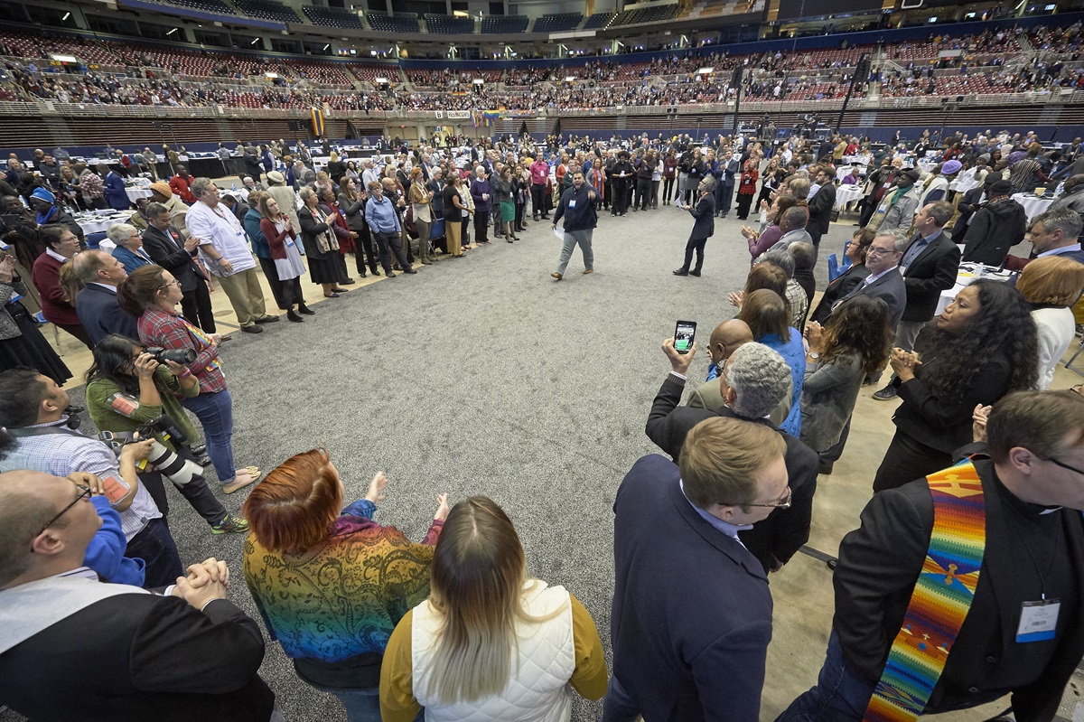 After a Feb. 26, 2019, vote to strengthen church policies about homosexuality, delegate Ian Urriola from New York speaks to other delegates who, in protest, formed a large circle in the center of the plenary floor. Photo by Paul Jeffrey, UMNS.