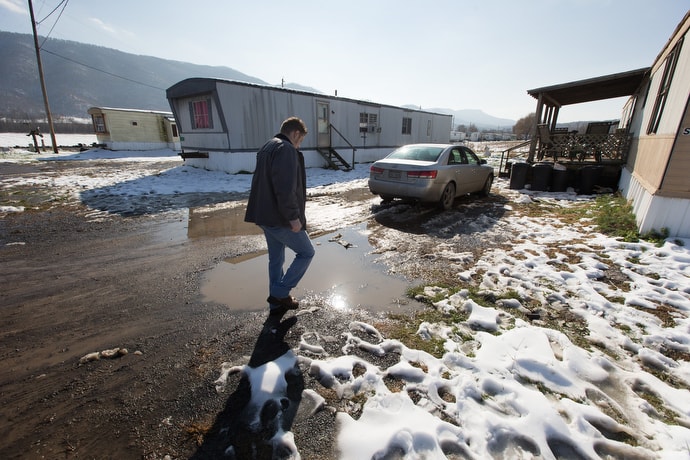Wayne Worth makes his way through a trailer park in Fisher, W.Va., while going door to door with resource information for people struggling with addiction. The flyers include numbers for 844-HELP4WV, a statewide hotline for anyone needing addiction support.