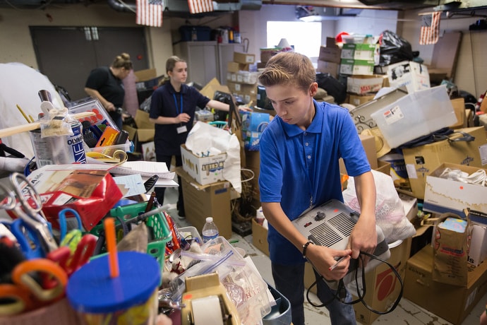 Skyler (front) helps sort donated household goods that will be sold in the thrift store at House of the Carpenter in Wheeling, W.Va. He was among a group of middle school students taking part in House of the Carpenter’s Pre-Work Camp. Photo by Mike DuBose, UM News.