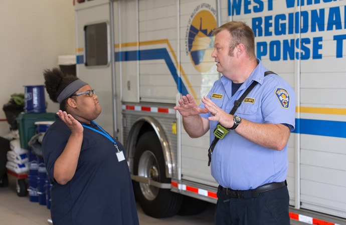 Zariah (left) visits with Lt. Bill Wagner at Fire Station 5 in Wheeling, W.Va. during a field trip for students in House of the Carpenter’s Pre-Work Camp. Photo by Mike DuBose, UM News.