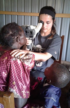 Olivia Halvorson, a volunteer with the Wesley Foundation Methodist Student Network of the University of South Carolina, checks a patient’s eyes during a health camp in eastern Uganda. Photo by Vivian Agaba, UM News. 