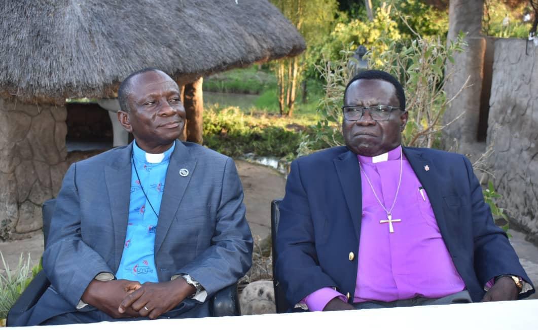 The Rev Alan Masimba Gurupira, administrative assistant to Bishop Eben K. Nhiwatiwa, sits next to South Congo Bishop Owan Kasap at a farewell dinner at Bouche Camp in Lubumbashi, Congo. A delegation of 12 lay and clergy members from the Zimbabwe Episcopal Area traveled to South Congo to exchange ministry ideas and strategies for church growth. Photo by Chenayi Kumuterera, UM News.